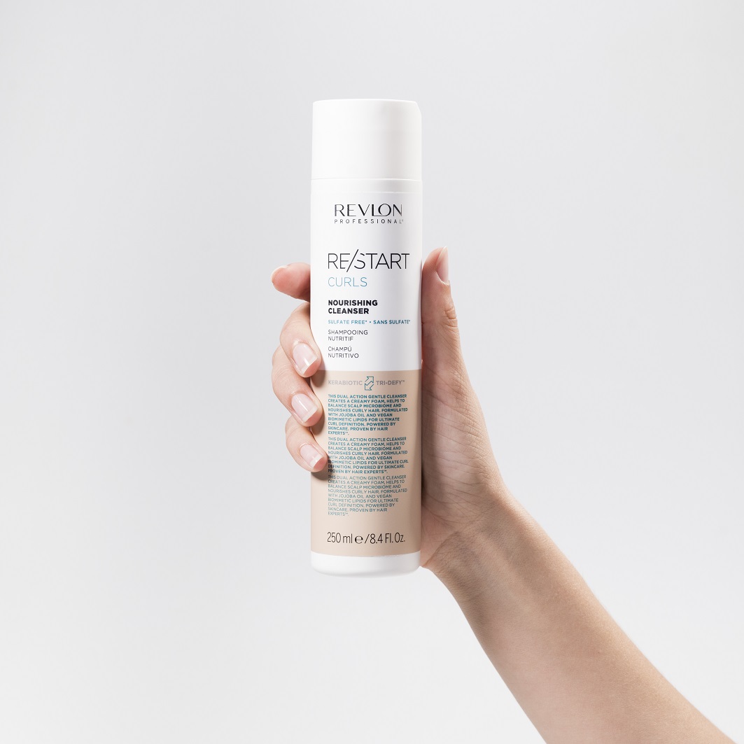 revlon-re-start-curls-nourishing-cleanser-shampoo-fuer-locken-weiss-orange-flasche-250-ml-in-der-hand